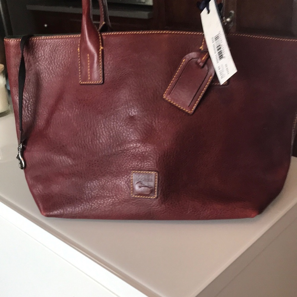Dooney Small Russel. Approx 17” W by 10” H. It is Florentine leather. Bordeaux.